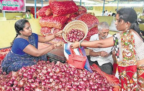 A woman buys onions at Swaraj Maidan Rythu Bazar in Vijayawada | EXPRESS
