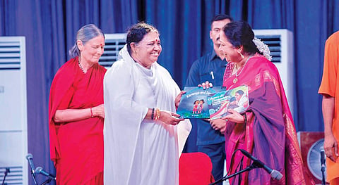 Lakshmi Menon, CEO, TNIE receiving a book from Mata Amritanandamayi as part of a book release function organised ahead of Amma’s birthday on Thursday