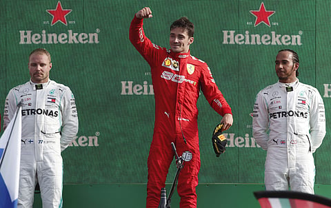 Ferrari driver Charles Leclerc of Monaco, center, celebrates with runner-up Mercedes driver Valtteri Bottas of Finland, left, and third placed Mercedes driver Lewis Hamilton of Britain, on podium after winning the Formula One Italy Grand Prix at the Monza