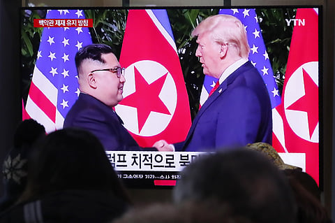 People watch a TV screen showing a file image of North Korean leader Kim Jong Un and US President Donald Trump. (File Photo | AP)
