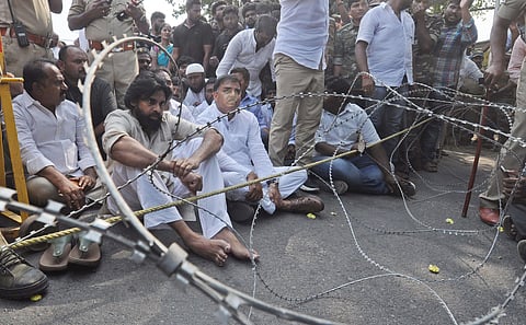 anasena chief Pawan Kalyan who is going to Mandadam to interact with farmers sits on road as police arranged metal fensing to block him at Penumaka-Venkatayyapalem junction. (Photo | Prasant Madugula, EPS)