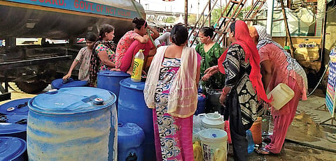 Residents in Harkesh Nagar fill buckets and drums with water from a Delhi Jal Board tanker (Photo | Somrita Ghosh)