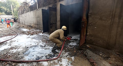 Firemen try to douse fire after a factory manufacturing batteries caught fire and collapsed in Peera Garhi area in New Delhi on Thursday. (Photo | Shekhar Yadav/EPS)