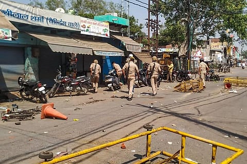 Police personnel inspect the area after a protest against the state government over the death of a 19-year-old Dalit woman who was brutally gang-raped two weeks ago. (Photo | PTI)