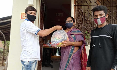 Dhilli Rao and Rupesh Kumar delivering groceries to people in Mandasa. (Photo | EPS)