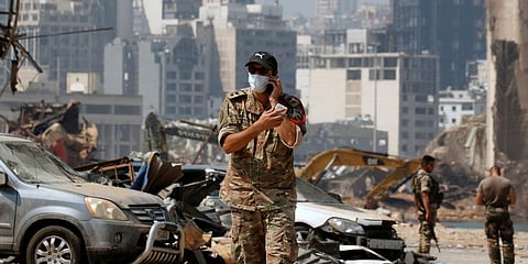 A Lebanese soldier uses his phone at the damaged site of the massive blast in Beirut's port area, in Beirut. (File Photo | AP)