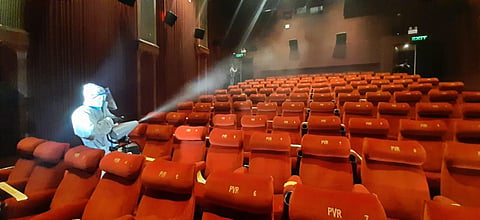 A worker sanitises inside a theatre hall ahead of the scheduled reopening of cinema theatres on October 15. (Photo | Shekhar Yadav)