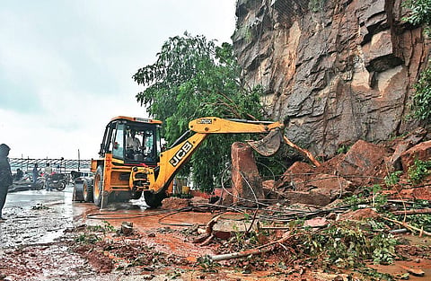 Boulders being cleared with an earthmover at ghat road of Indrakeeladri in Vijayawada on Tuesday I Prasant Madugula