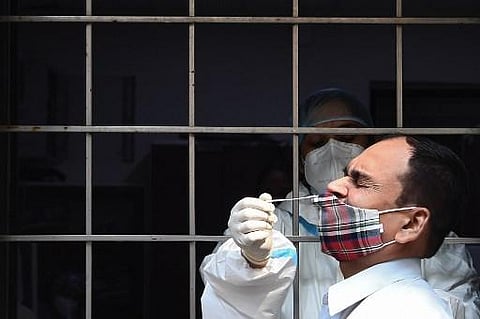 A health worker collects a swab sample from a resident to test for the Covid-19 coronavirus. (File Photo| AFP)