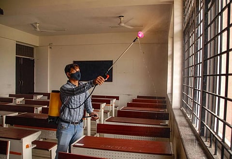 A worker sanitises a class room as authorities have allowed for the reopening of educational institutes in a graded manner. (File Photo | PTI)