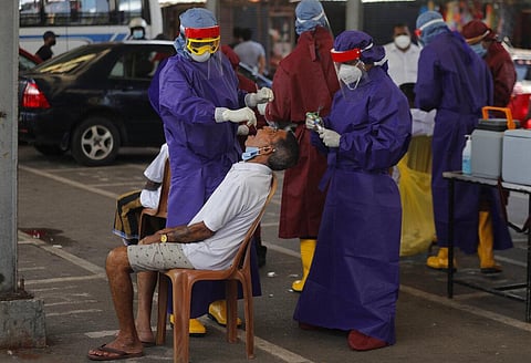 Sri Lankan health workers take a swab sample from a man to test for COVID-19 in Colombo, Sri Lanka, Thursday, Oct. 22 (Photo | AP)