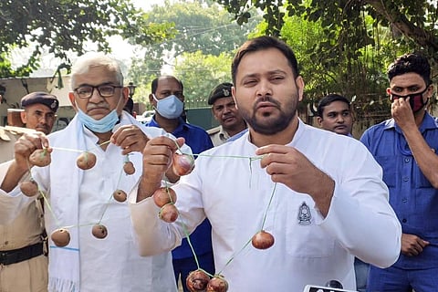 RJD's Tejashwi Yadav holds an onion garland during a protest over hike in the prices of the vegetable in Patna Monday Oct. 26 2020. (Photo | PTI)