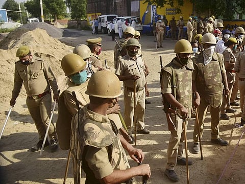 Police personnel stand guard near a barricade on a road leading to Bulgari village. (Photo | PTI)