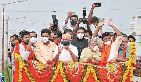 Chief Minister B S Yediyurappa takes part in a roadshow to campaign for BJP candidate Dr C M Rajesh Gowda in Sira on Friday