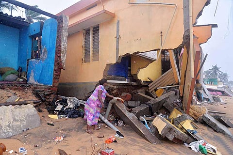 A woman trying to collect debris after a portion of her house was washed away by sea erosion. (Photo | Vincent Pulickal, EPS)