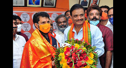 Munirathna, who recently won the RR Nagar bypoll, with BJP National General Secretary CT Ravi, in Bengaluru, on Wednesday. (Photo | Special Arrangement)