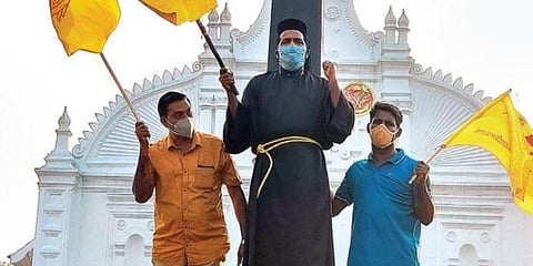 As a mark of protest, Fr Basil Kottikan ties himself to the cross in front of the St Thomas Church in Kothamangalam on Wednesday. (Photo| EPS)