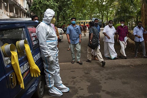 A man in protective suit stands next to a mobile COVID-19 testing kiosk outside the Ernakulam district administration headquarters in Kochi, Kerala. (Photo | AP)