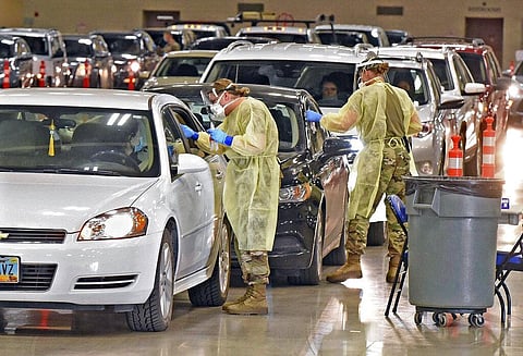 North Dakota National Guard soldiers Spc. Samantha Crabbe, left, and Master Sgt. Melanie Vincent administer COVID-19 tests inside the Bismarck Events Center in Bismarck, N.D. (Photo | AP)