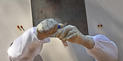 Health worker carefully seals the cap of VTM after collecting sample for ccoronavirus at IGMC Stadium in Vijayawada on Saturday. (Photo | EPS/Prasant Madugula)