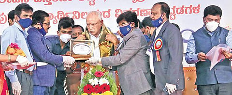 Vice-Chancellor of Kuvempu University Prof B P Veerabhadrappa felicitates Chief Minister B S Yediyurappa in Shivamogga on Sunday. (Photo | EPS/Shimoga Nandan)
