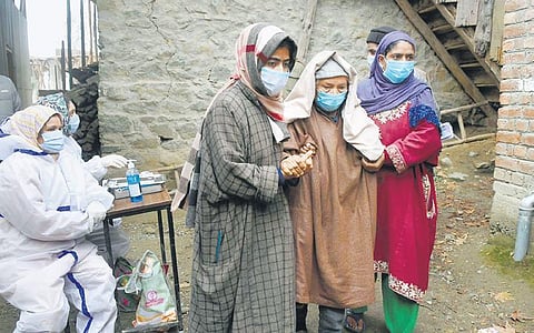 An elderly voter being escorted by her daughters as she arrives to cast her vote for the fifth phase of DDC elections, at Wakura on Thursday. (Photo | PTI)