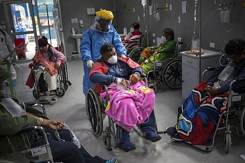 A doctor pushes a COVID-19 patient in a wheelchair in the emergency area of the Guillermo Almenara hospital in Lima, Peru. (Photo | AP)
