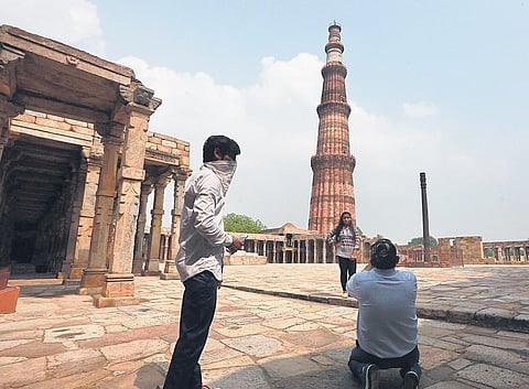 Visitors click pictures near Qutub Minar on Monday, when monuments were reopened for public. (File Photo | Shekhar Yadav)