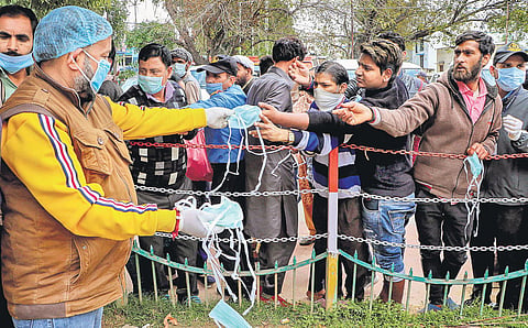 A volunteer distributes masks to people as a preventive measure in Jammu | Pti