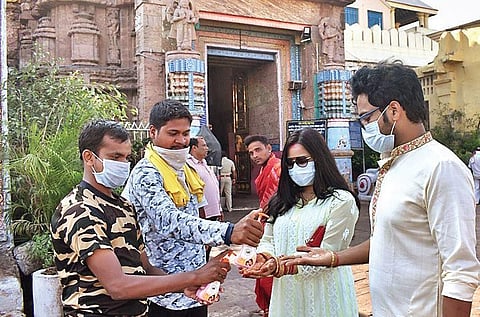 Volunteers providing hand wash to devotees outside Sri Jagannath temple on Monday. (Photo | Ranjan Ganguly, EPS)