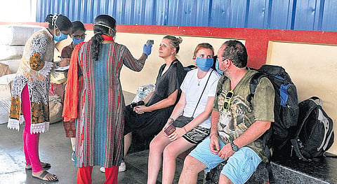Health workers and police officials screening foreign tourists who arrived at Ernakulam Junction railway station from Thiruvananthapuram. They were shifted to a hospital after they were found to have symptoms of Covid-19 | A Sanesh