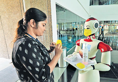 A robot providing a mask and hand sanitiser to a visitor at the Integrated Startup Complex in Kochi on Tuesday | Arun Angela