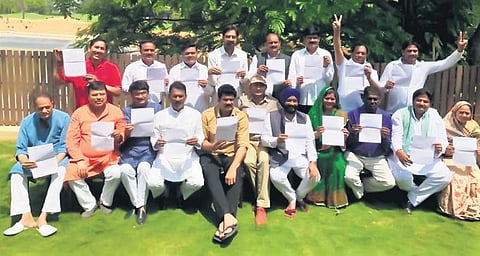 The Madhya Pradesh rebel Congress MLAs pose with their resignation letters in Bengaluru on Tuesday. (File photo | EPS)