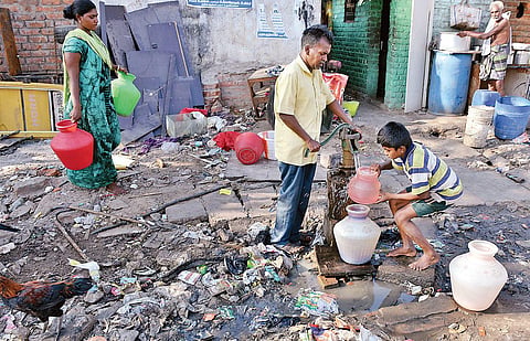 Chennaiites collecting water as a drain overflows in Pudhupet