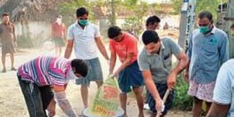 Youngsters from Palapadu spray bleaching powder on the streets. (Photo| EPS)
