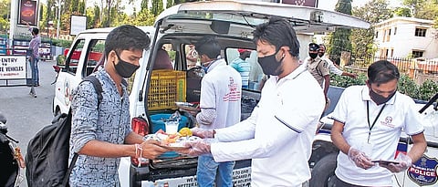 The workers of an NGO distribute free food to the needy near the JBS bus station in Hyderabad on Thursday (Photo | Sathya Keerthi, EPS)