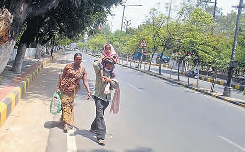 A family of migrant workers, who are headed for their hometown of Achampet, walk under a hot sun in Secunderabad on Saturday | SATHYA KEERTHI