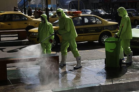 City workers disinfect a bench because of the new coronavirus in Tehran. (Photo | AP)