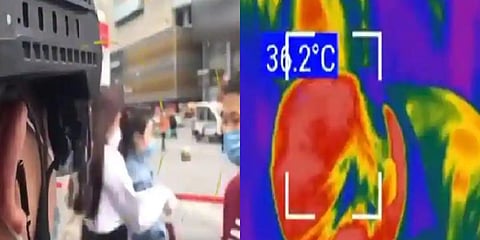 The video shows the officers looking around to screen passing shoppers to see if their body temperatures were above 37.3 degrees Celsius. (Photo | PD China Twitter)