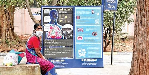 A woman with a mask sits under the shade of a tree at Ruia government hospital in Tirupati on Saturday. (Photo| Madhav K, EPS)