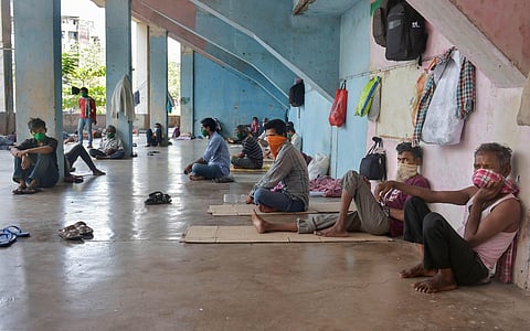 Migrant workers and homeless people rest at a temporary camp set up on the premises of a stadium, during ongoing COVID-19 lockdown in Thane. (Photo | PTI)