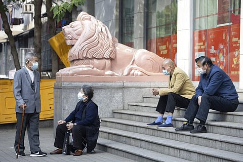 Elderly residents wearing masks against the coronavirus wait outside a bank in Wuhan in central China's Hubei province Thursday, April 16, 2020. (Photo | AP)