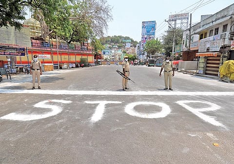 Sanitation workers wrote ‘Stop’ on the road to restrict people from entering a contaminated zone at Machacaram in Vijayawada on Wednesday. (Photo | EPS/Prasant Madugula)