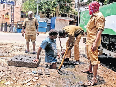 GHMC workers seen cleaning a manhole under unhygienic conditions during the lockdown at Gudimalkapur in Hyderabad on Wednesday| sathya keerthi