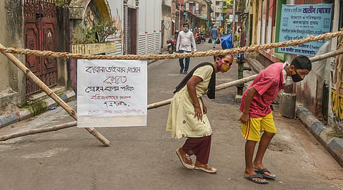 People cross barricades where a notice on 'no entry of outsiders' can be seen during a nationwide lockdown imposed in the wake of coronavirus pandemic.(Photo | PTI)