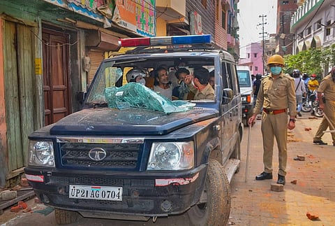 A team of medical personnel and police along with the family members of a person who died of COVID-19 sit inside a vandalised ambulance after a mob attacked their vehicle with stones in Moradabad Wednesday. (Photo | PTI)