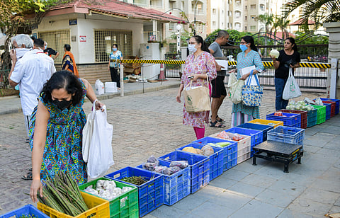 A vegetable vendor brings his truck and arranges them neatly outside an apartment twice a week. Residents shop keeping the restrictions in mind which is supervised by the association on Thursday in Bengaluru. (Photo | Meghana Sastry/EPS)