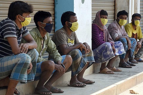 Construction and dailway wage labourers waiting for their afternoon food packets. (Photo | Nagaraja Gadekal, EPS)