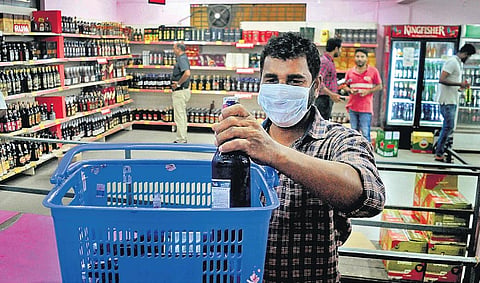 A mask-clad man buys alcohol from a Bevco outlet in Kochi before the lockdown| A Sanesh