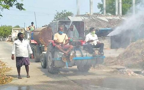 People spraying sodium hypochlorite at Chagallu village in Nekarikallu mandal of Guntur district on Friday I Express